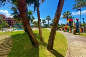 un parc avec des palmiers et une aire de jeux dans l'établissement El Paraíso de Carmen, à Motril