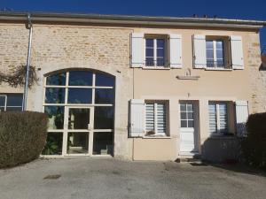 a brick building with a large door and windows at Studio Sylvain in Neuilly-lʼÉvêque