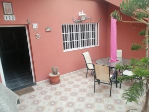 una stanza con tavolo, sedie e parete rosa di El Girasol a Arinaga