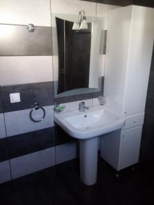 a bathroom with a white sink and a mirror at Villa Oniro Kreta in Kalamaki