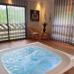 a large jacuzzi tub in the middle of a room at Etangs du Moulin in Suzy