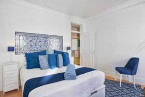 - une chambre avec un grand lit et des oreillers bleus dans l'établissement Charming apartment Castelo. Amazing Lisbon View, à Lisbonne