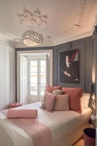 - une chambre avec un grand lit et des oreillers roses dans l'établissement Charming apartment Castelo. Amazing Lisbon View, à Lisbonne
