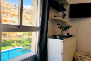 een kamer met uitzicht op een zwembad door een raam bij Piso en zona tranquila de - Torrequebrada Golf in Benalmádena