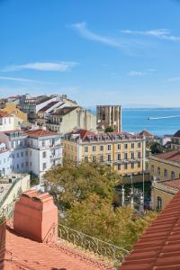 - une vue sur la ville avec ses bâtiments et l'océan dans l'établissement Charming apartment Castelo. Amazing Lisbon View, à Lisbonne