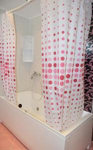 a bathroom with a bath tub with polka dot shower curtain at dream apartment in Obzor