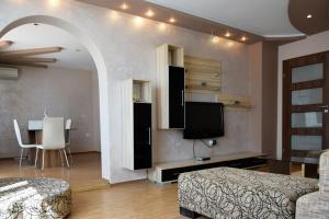 a living room with a bed and a tv and a table at dream apartment in Obzor