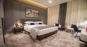 a hotel room with a large bed and chairs at Rose Executive Hotel - DWTC in Dubai +52 photos