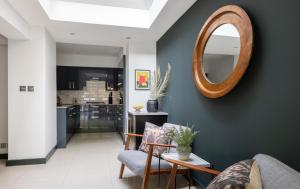 a living room with a mirror on the wall at The Heart of Shepherds Bush - Modern 2BDR Apartment with Garden in London