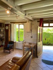 a living room with a couch and a table at Petite maison au bord du canal, 8' Zoo de Beauval, PMR in Noyers-sur-Cher