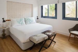 a bedroom with a large white bed and two windows at Hotel Fariones in Puerto del Carmen