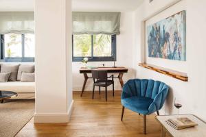 a living room with a blue chair and a table at Hotel Fariones in Puerto del Carmen