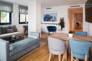 a living room and dining room with a table and chairs at Hotel Fariones in Puerto del Carmen