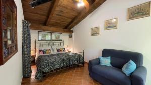 um quarto com uma cama e um sofá num quarto em Agriturismo La Casa Del Ghiro em Pimonte