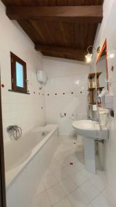 un bagno bianco con vasca e lavandino di Agriturismo La Casa Del Ghiro a Pimonte