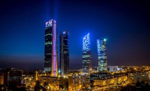 a city lit up at night with tall buildings at Hotel Chamartin The One in Madrid