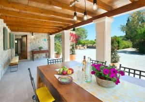 a wooden table with fruit and flowers on a patio at Owl Booking Villa Rafale - 5 Min Drive to The Beach in El Port +42 photos
