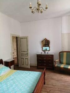- une chambre avec un lit, une chaise et un miroir dans l'établissement MAISON ALBA LA SOURCE, à Mazamet