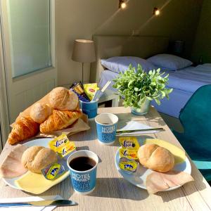 a table with sandwiches and croissants and cups of coffee at Hotel Franky in Blankenberge