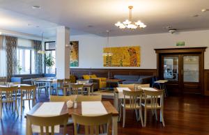 un comedor con mesas y sillas en un restaurante en Hotel Relaks Wellness & SPA, en Karpacz