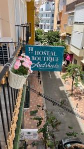 a sign on a balcony with a basket of flowers at Hotel Boutique Andalucia in Fuengirola