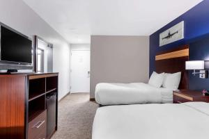 a hotel room with a bed and a television at Avion Inn Near LGA Airport, Ascend Hotel Collection in Queens