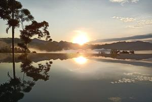 a reflection of the sun in a lake at sunset at Puluong Home in Pu Luong