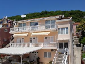 an apartment building with a white balcony and stairs at R&S Apartments in Herceg-Novi