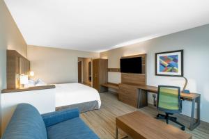 フェニックスにあるHoliday Inn Express & Suites - Phoenix - Airport North by IHGのベッドと机とテレビがあるホテルの部屋