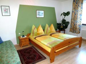 een slaapkamer met een groot houten bed met gele kussens bij Ferienwohnung Weinbergblick in Oberrohrendorf