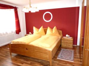 een slaapkamer met een bed met een rode muur bij Ferienwohnung Weinbergblick in Oberrohrendorf
