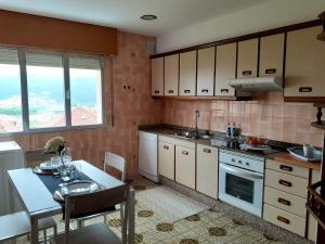 a kitchen with white cabinets and a table with a tableablish at O Recuncho de Macías in Laxe