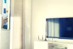 a living room with a flat screen tv on a cabinet at Apartamento Con Piscina Lloret de Mar in Lloret de Mar