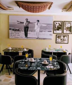 ein Esszimmer mit zwei Tischen und einem Bild an der Wand in der Unterkunft Santa Sophia Del Mar B&B hotel in Santa Marta