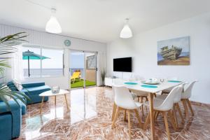 ein Wohnzimmer mit einem Tisch, Stühlen und einem Sofa in der Unterkunft Coastal Dream with heated pool in El Escobonal