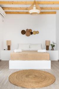 a white room with a bed on a white wall at Milia Apartments in Paralia Milia