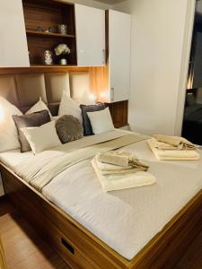 ein großes Bett mit zwei Handtüchern darüber in der Unterkunft mariTIME deluxe in Portorož