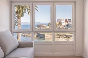 una sala de estar con una ventana con vistas al océano en Apartamento Fisterra con vistas al mar, en Finisterre