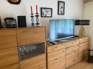 a television on a wooden dresser with two red candles at Superior Apartment 100m2 Bodmisonne - Grindelwald in Grindelwald