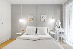 biała sypialnia z dużym łóżkiem i 2 krzesłami w obiekcie Blue Mare Dubai Kasprowicza 20B, FREE Pool, Sauna, Parking, Fitness w Kołobrzegu