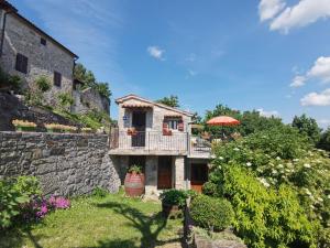 a house with a balcony and a stone wall at Apartment Franko - Hum in Hum