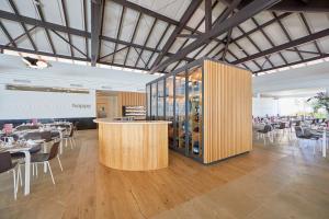 a restaurant with a bar and tables and chairs at Prinsotel La Dorada & Spa in Playa de Muro