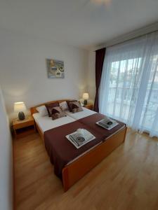 a bedroom with a large bed and a large window at Apartmani Delač in Vodice