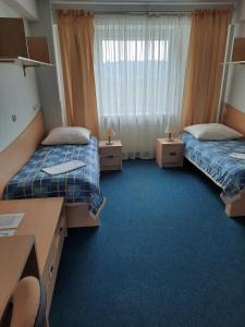 ein Hotelzimmer mit 2 Betten und einem Schreibtisch in der Unterkunft DS Za Kolumnami in Krakau