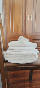 a stack of white towels sitting on a chair at Pensión Nigrán in Nigrán