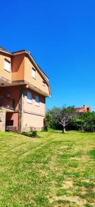 a house with a grassy yard in front of it at Pensión Nigrán in Nigrán