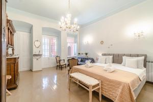 - une chambre avec un grand lit et un salon dans l'établissement Neoclassical Mansion in Andros Town, à Andros