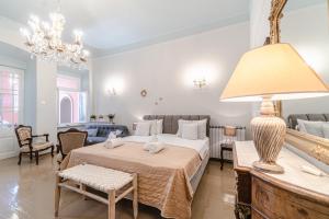 1 dormitorio con 1 cama y 1 mesa con lámpara en Neoclassical Mansion in Andros Town, en Ándros