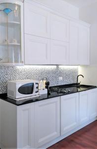 eine Küche mit weißen Schränken und einer Mikrowelle auf der Theke in der Unterkunft San Luca Apartment in Venedig