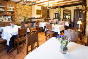 a restaurant with tables and chairs with flowers on them at La Casona de Tresgrandas in Tresgrandas +63 photos